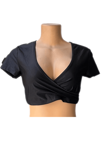 Vista de frente. Blusa corta negra con escote profundo y diseño cruzado al frente.