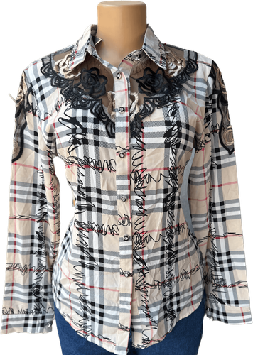 Vista de frente (uno de dos). Una blusa de manga larga con un estampado de cuadros en tonos crema y detalles bordados en negro.