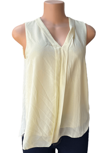 Vista de frente (una de dos). Una blusa de gasa amarilla con un diseño sencillo y sin mangas, con un escote en V.