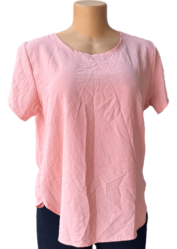 Vista de frente (una de dos). Blusa simple de color rosa con detalle decorativo en la espalda.